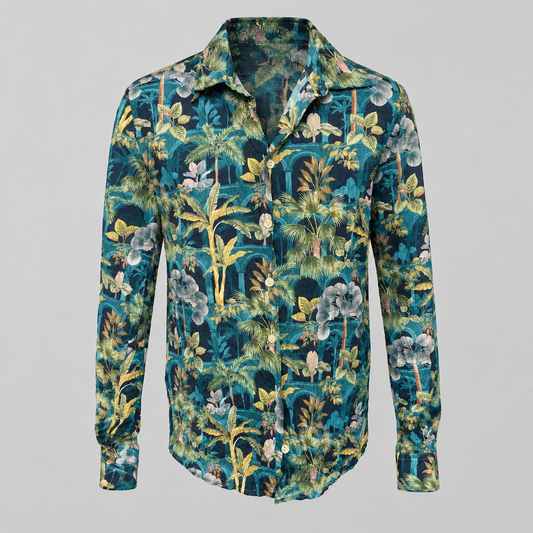 A long-sleeve button-up shirt with a dense tropical floral and palm leaf print in teal, green, navy, yellow, and white, displayed on a white mannequin torso in a boutique setting.