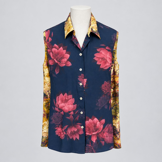 A long-sleeve button-up shirt displayed on a mannequin torso in a retail store. The shirt has a dark navy blue base with large pink floral prints and patterned gold sleeves.