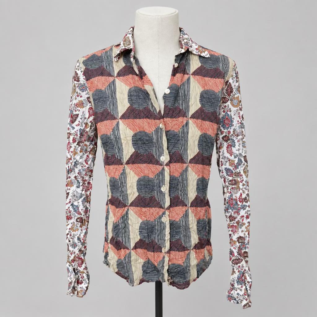 A long-sleeve button-up shirt with a geometric pattern in dusty pink, charcoal gray, and cream, displayed on a white mannequin torso inside a retail store.